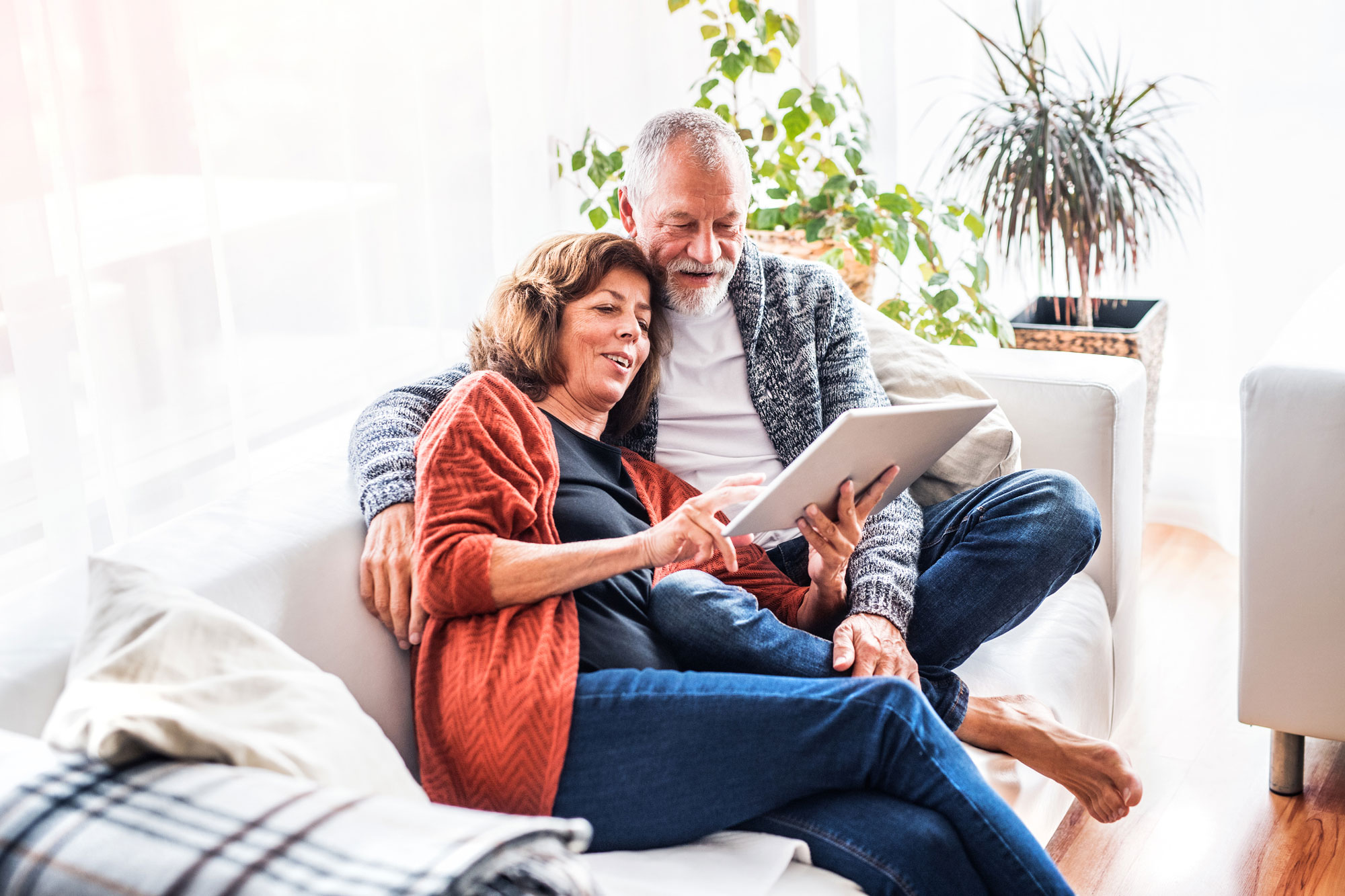 Elder Law Concept - Senior couple with tablet relaxing at home
